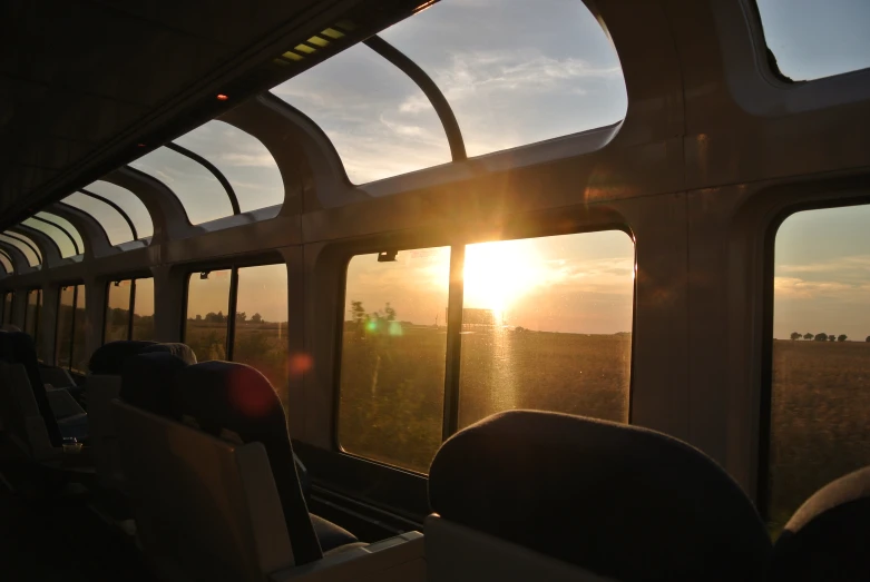 view from inside a train while the sun sets over a valley