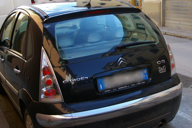 a small, black compact car parked at an intersection