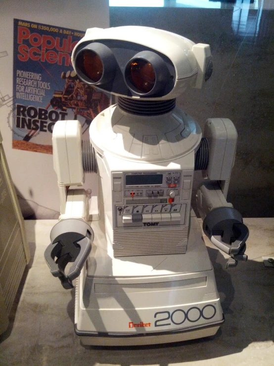 the robot toy sits on the table with his eyes open