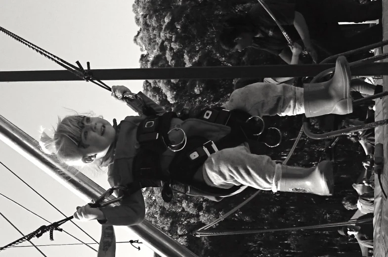 a child with safety gear is on the ropes in a playground