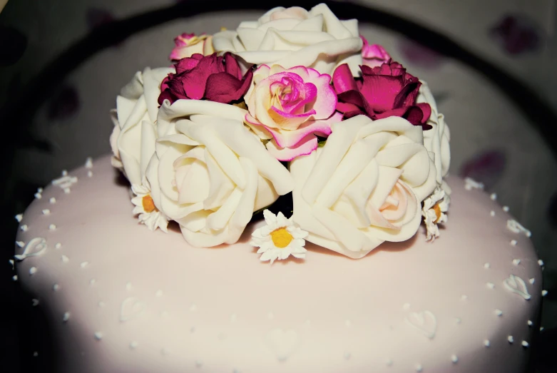 an arrangement of flowers sits on top of the wedding cake