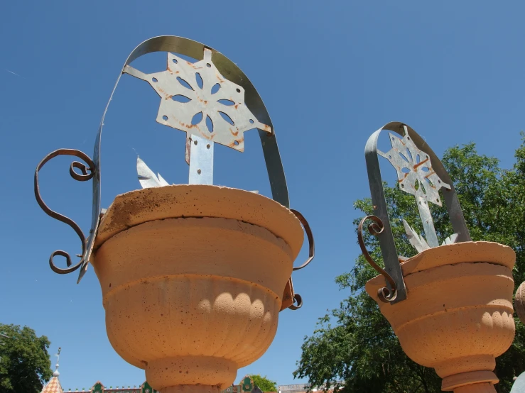 there are two metal items on the top of this flowerpot