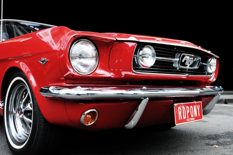 a red mustang car with chrome paint parked in a parking lot