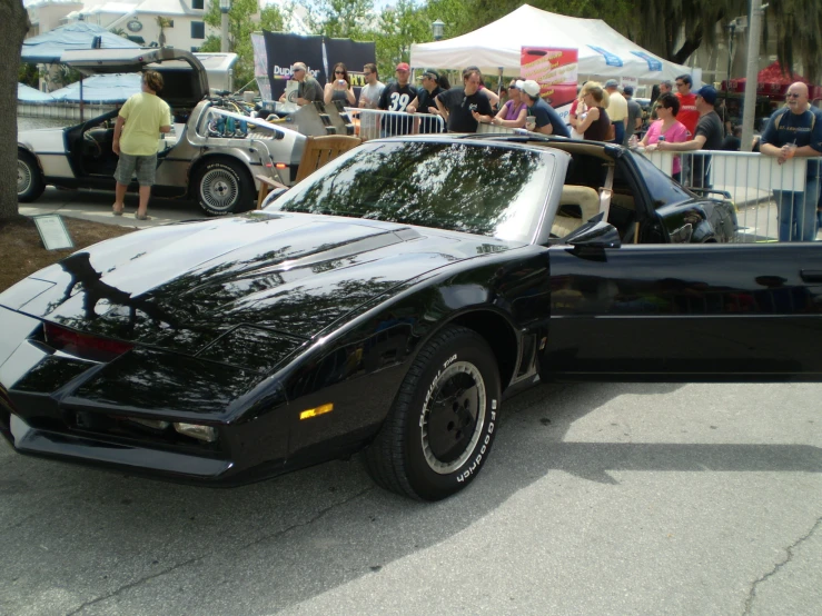 a black del ameo on the street near a car