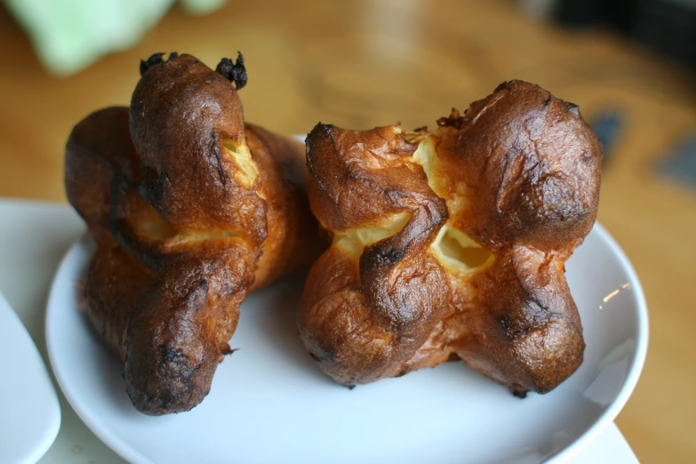 two croissant buns with lemon on a white plate