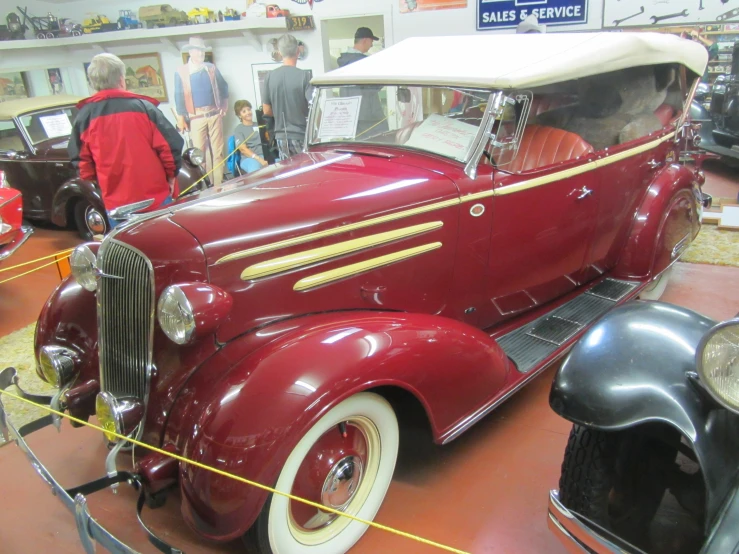 a red car is sitting on display in a museum