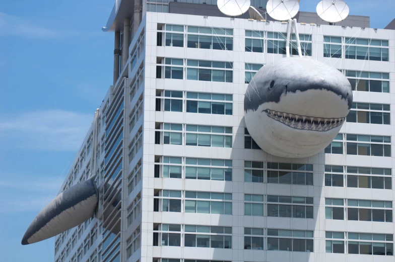 an office building with a giant shark sculpture in front of it