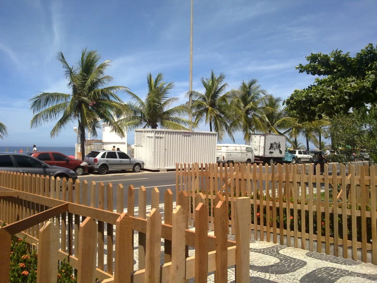 this is a fence at an island where palm trees are lining the street