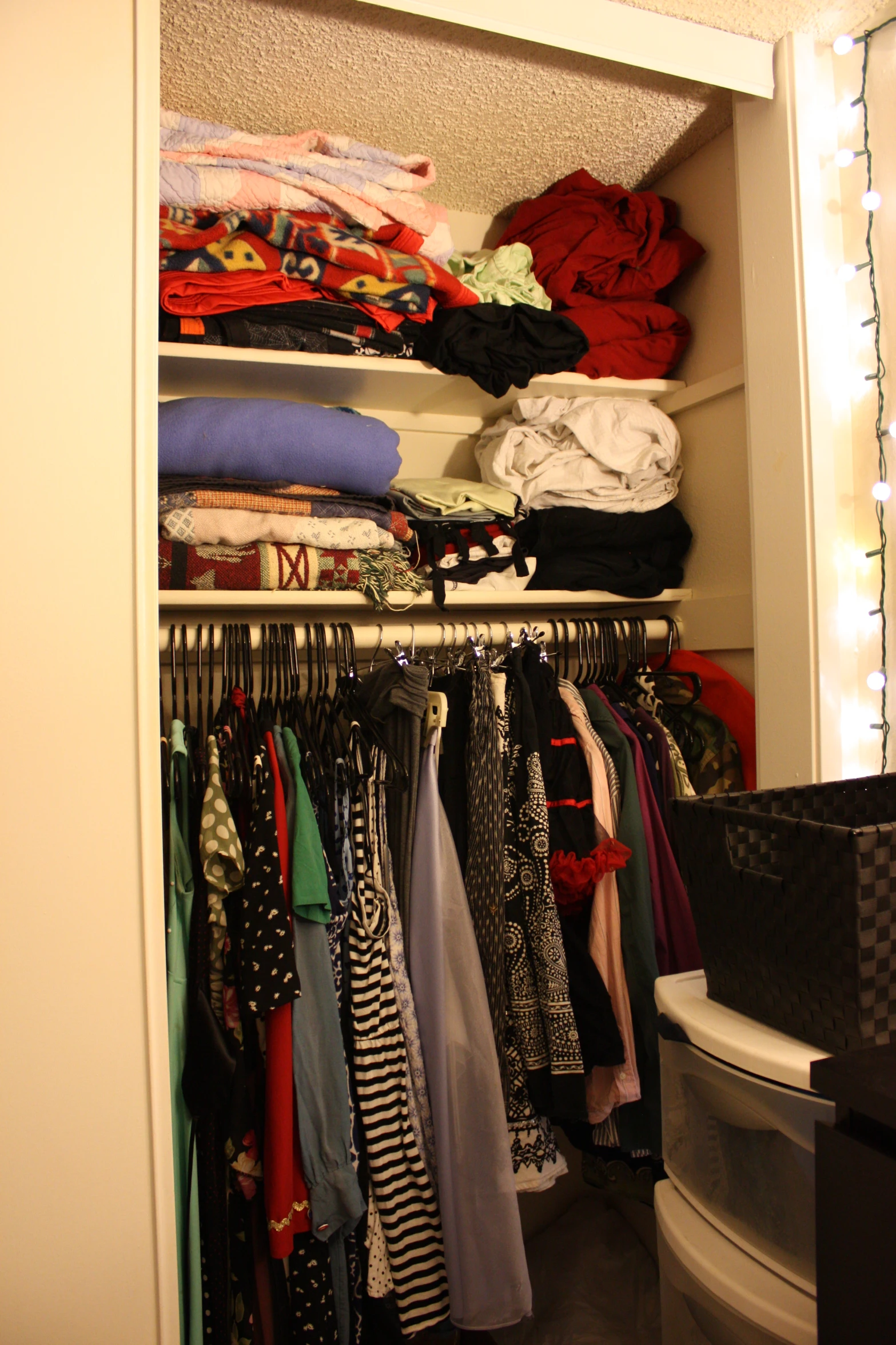 a closet filled with clothes and shirts next to a toilet