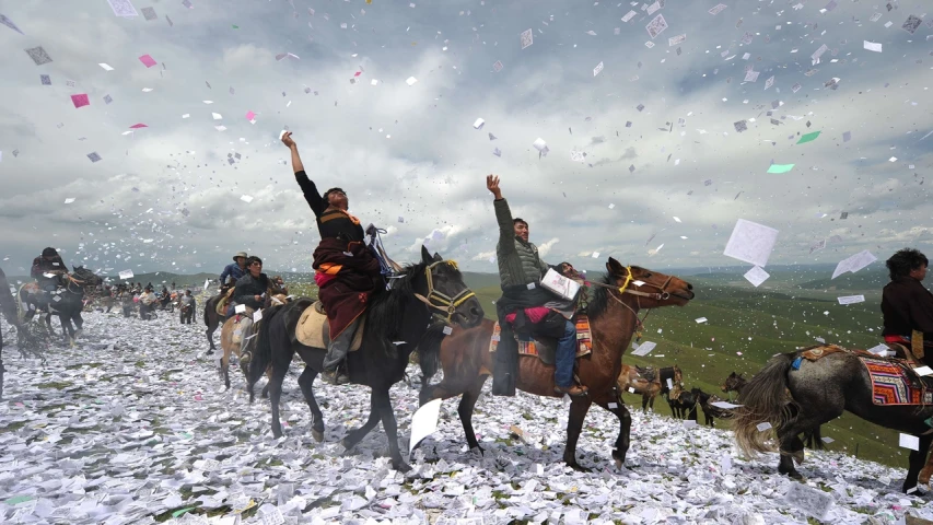 people ride horses and look up at a sky full of confetti