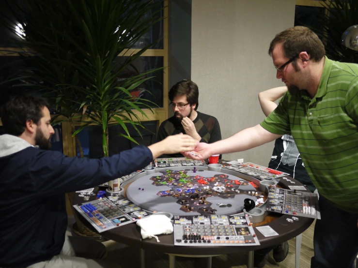 several people standing around a table that has many ons and dices on it