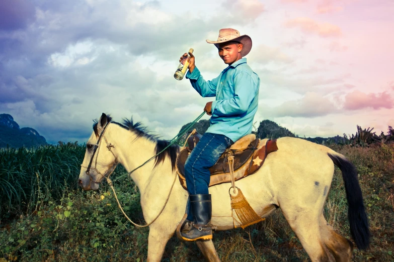 the man in blue shirt and cowboy hat is on his horse