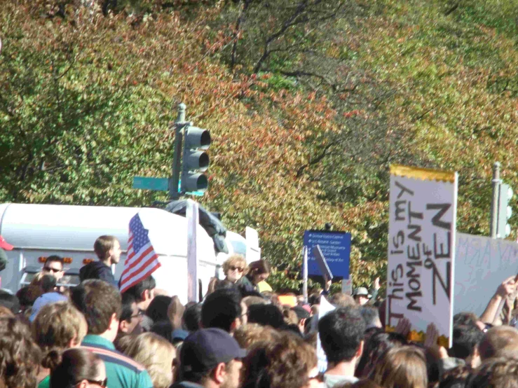 large crowd of people standing in front of a white van