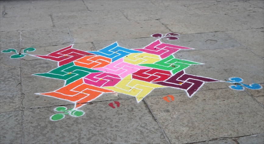 a colorful star and other letters painted on the ground