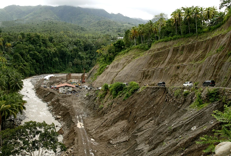 a large quarry in front of a river and a mountain side