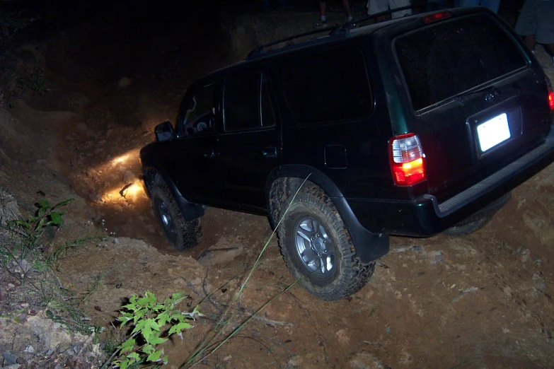 the back of a suv on dirt road at night