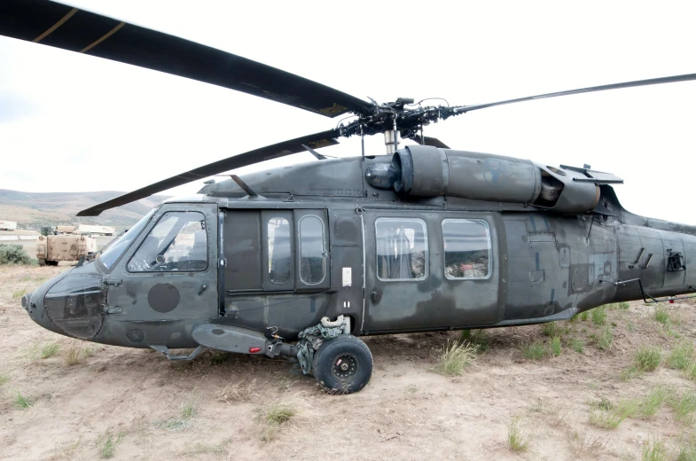 an old army helicopter sits in the dirt