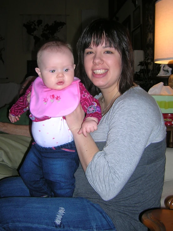 a smiling woman with a baby in her lap