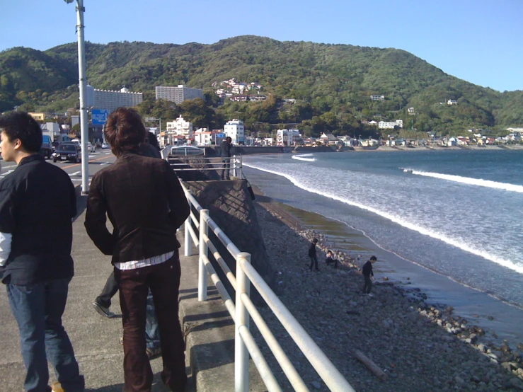 people standing on the pier overlooking the water