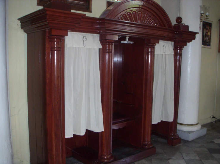 an open closet containing a desk with curtains, and a chair