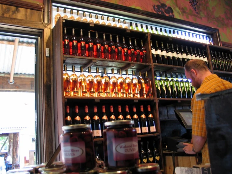 man browsing jars of beer in a shop