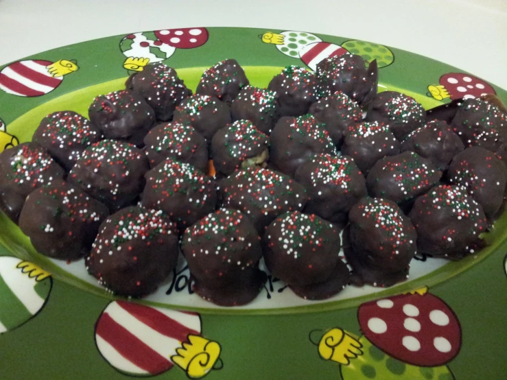 a green plate full of christmas chocolate covered cake bites