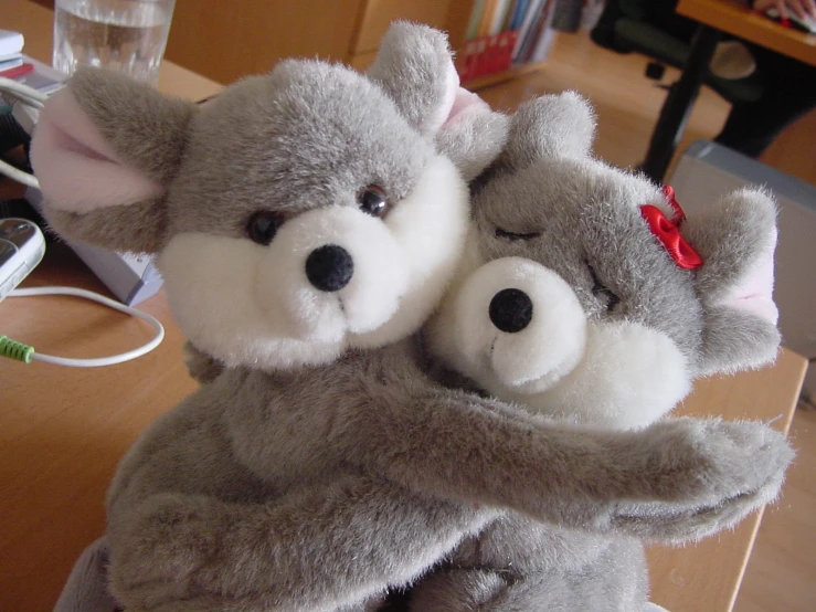 two stuffed animals holding each other in the shape of animals