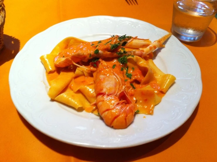 a white plate topped with pasta and shrimp