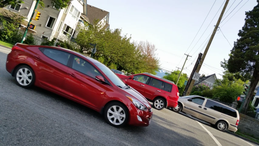 the red car is sitting next to another car on the street