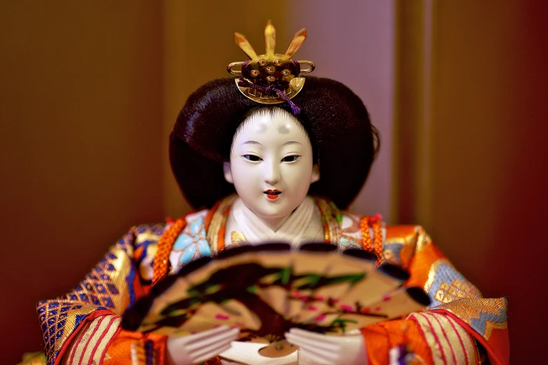 an asian doll that is holding a plate