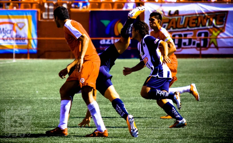 soccer players on field fighting for the ball