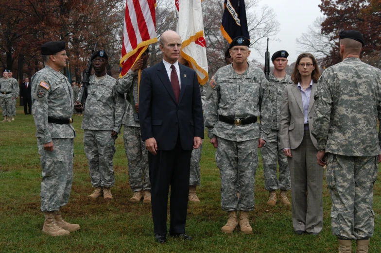 the military soldiers are posing for a picture with two men in suit and tie