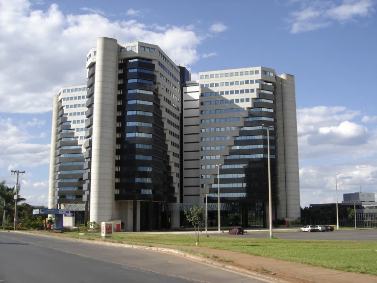 two tall buildings with many windows near one another