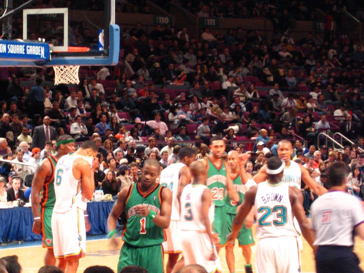 a group of men standing on a basketball court