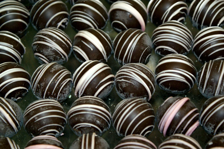 an assortment of chocolate truffles are in rows