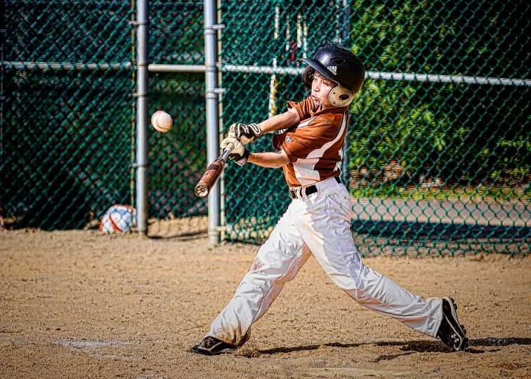 a  in uniform swinging at a baseball