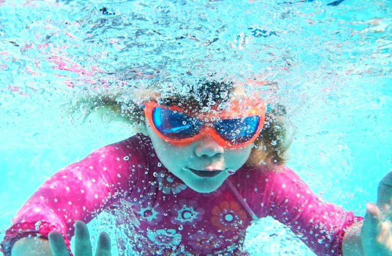 the child swims in the swimming pool