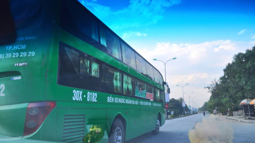 two busses driving in opposite directions on a road