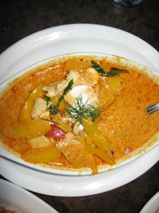 a white bowl filled with soup sitting on top of a table