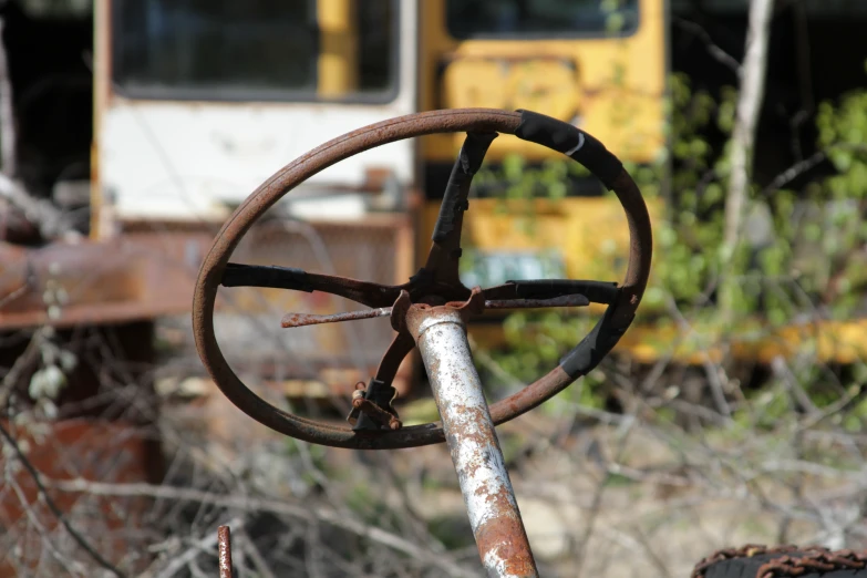 an old rusted metal steering and metal pole