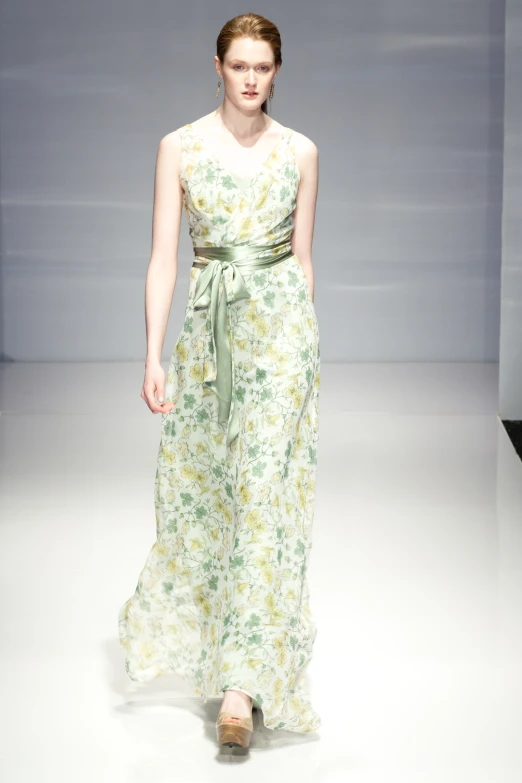 a dress with a green belt is on the runway