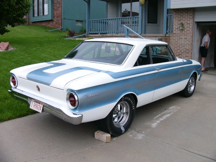 a classic car is parked in front of the house