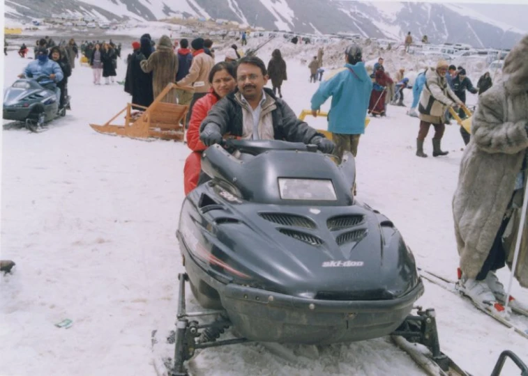 a man and a child on a snowmobile with a dog