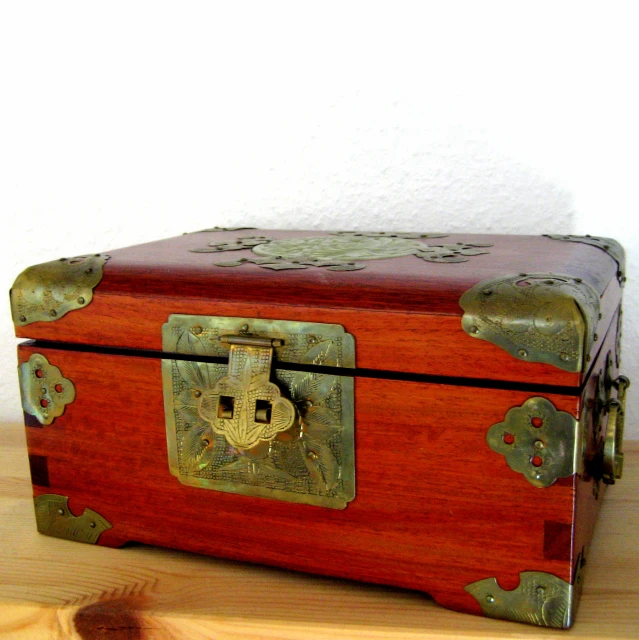a wooden trunk sitting on a table by a wall