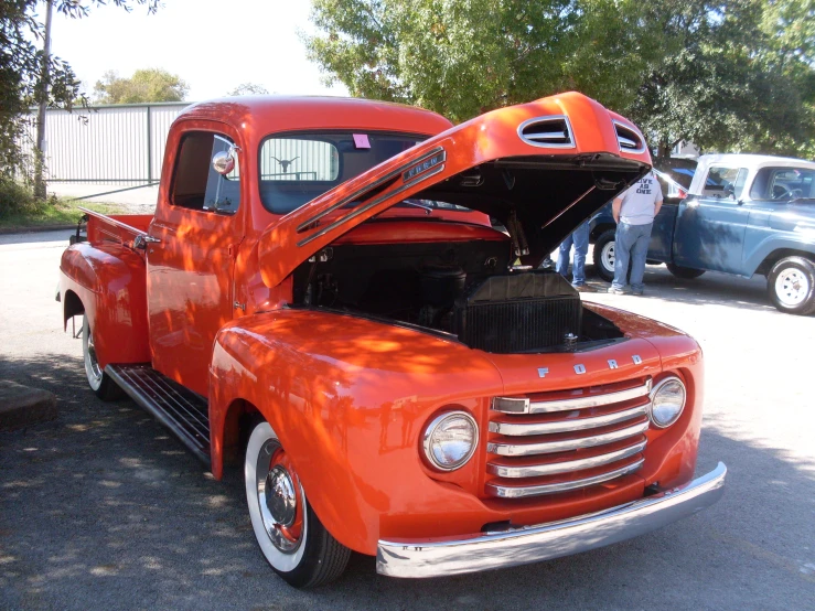 an orange pick up truck parked on a street