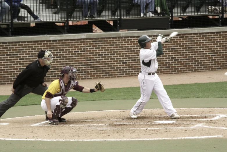 baseball player hitting a ball while the catcher and umpire look on