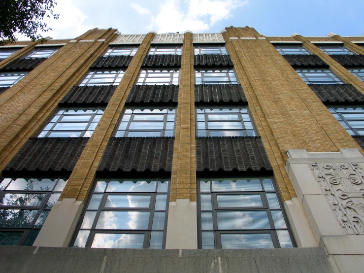 looking up at the side of a tall brown building