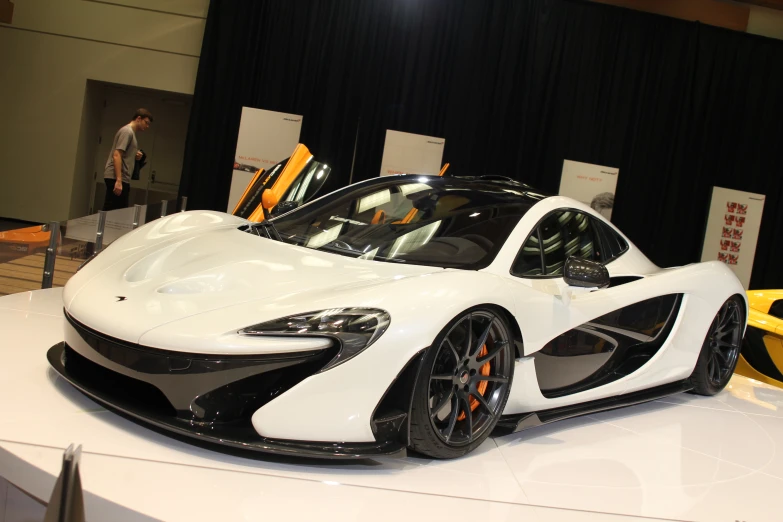 white and black colored sports car on display at event