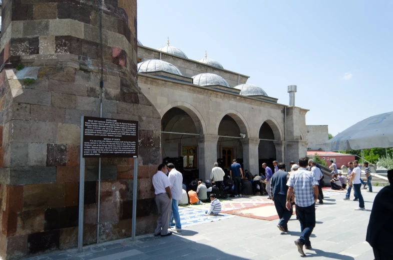 a large crowd of people standing around an old building