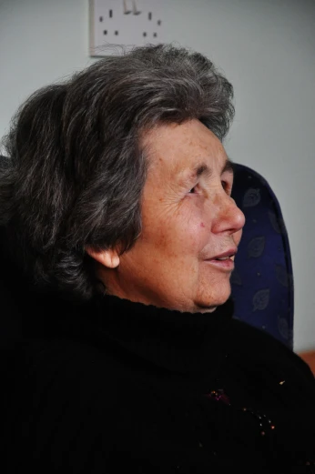 a woman sitting in a chair staring off into the distance